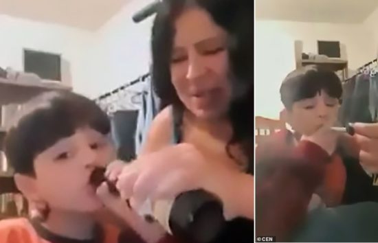 息子の首を押さえながらビールを飲ませる母親